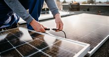 Installer connects a solar panel energy system to a building