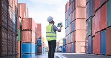 Man works between containers with a tablet
