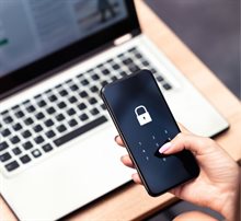 Cybersecurity pictured with laptop in the background and phone with login code in the foreground