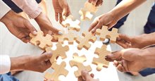 Handen plaatsen puzzelstukjes en werken samen