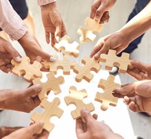 Handen plaatsen puzzelstukjes en werken samen