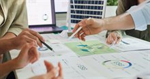 People pointing with pens at paper analyses on the table