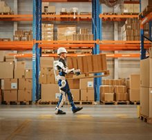 Man holds box while a robot supports him