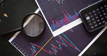Grafieken met een vergrootglas en rekenmachine, symbool voor analyseren en berekenen